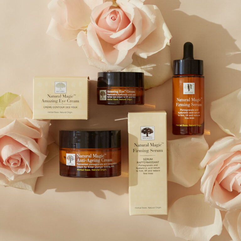 „Natural Magic™“ sērijas produkti, izstādīti kopā ar gaiši rozā rozēm.