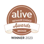 „Alive Retailer Choice Awards“ bronzas medaļas nozīmīte — apaļā brūnā nozīmīte ar lenti, uz kuras uzrakstīts „Winner 2023”.
