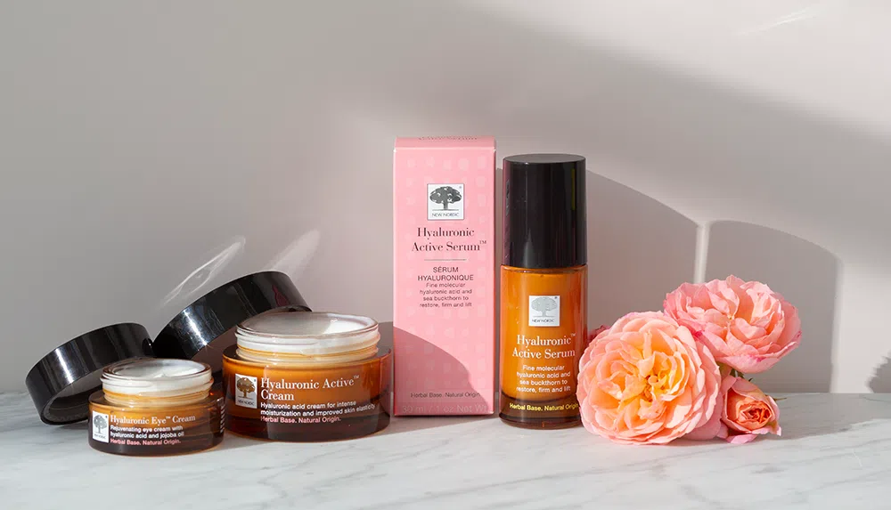 mūsu „Hyaluronic Active” pudelīšu komplekts un kastīte ar rozā kārbiņu un rozā ziedu