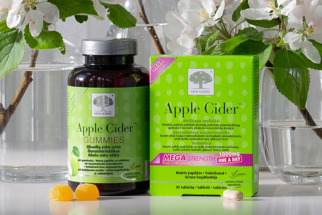 Apple Cider Gummies un Apple Cider produktu iepakojumi ar zaļām lapām un ziediem fonā